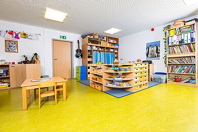 Familiengruppe im 1. OG, Lese- und Spieleecke. Es sind viele Gesellschaftsspiele und Bücher in Regalen erkennbar.
