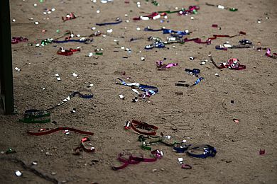Auf dem Boden des Gartens liegen bunte Luftschlangen und Konfetti.