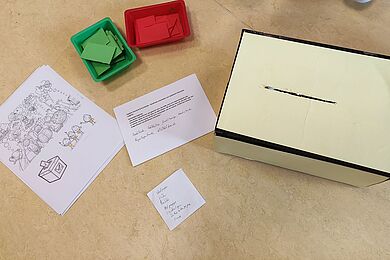 Wahlurneund Abstimmungszettel in Grün und Rot