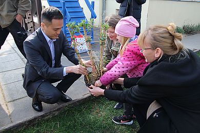 Zwei Kinder der Kita "Schröderstraße" übergeben einen Sommerflieder an Ken Toko