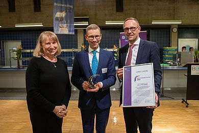 von links nach rechts: Staatsministerin Petra Köpping, Prof. Dr. med. Michael Fuchs, Leiter der Sektion Phoniatrie und Audiologie (hält den Brückenschlag-Preis in der Hand) und Hauptgeschäftsführer Tobias Schmidt (hält die Urkunde in der Hand)