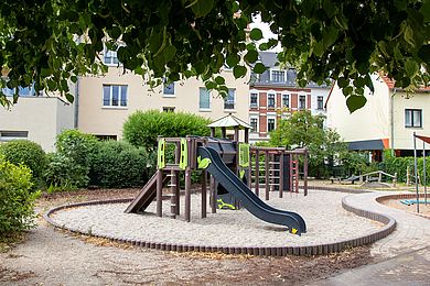 Spielplatz mit Rutsche und Kletterelementen auf dem Kita-Gelände