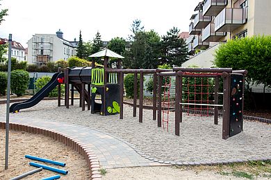 Blick auf den Spielplatz der Kita mit Rutsche und Klettermöglichkeiten