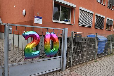 Ein bunter Luftballon in Form einer 20 begrüßt alle Gäste am Eingangstor der Kita Gerne Groß.